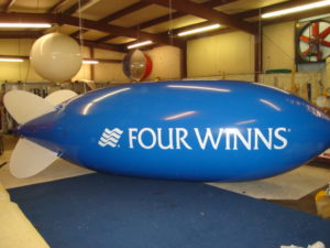 advertising blimps for promotions. blue blimp with logo in white. Houston